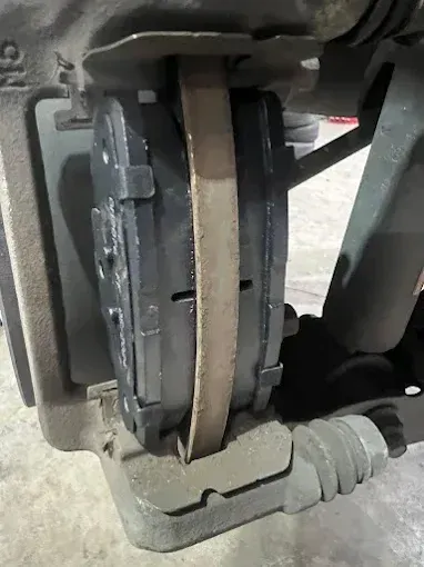Close-up of a brake pad and disc during a brake inspection