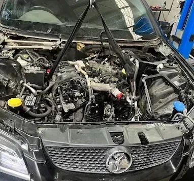 Holden engine bay with the intake removed during an engine repair