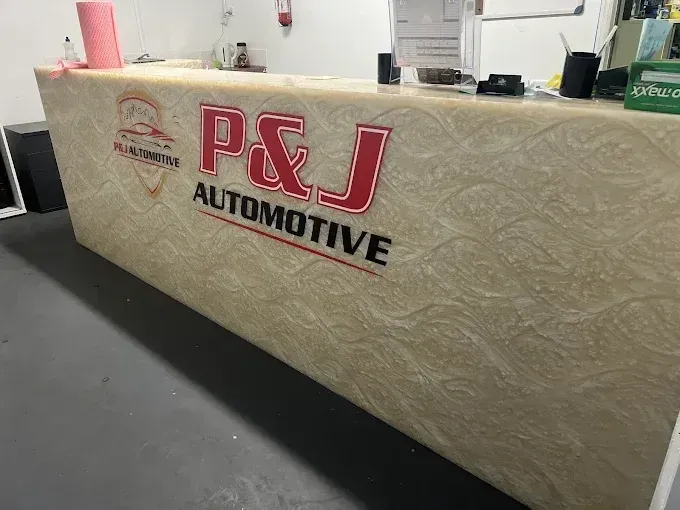 P&J Automotive logo on the front counter at the Sunshine North workshop