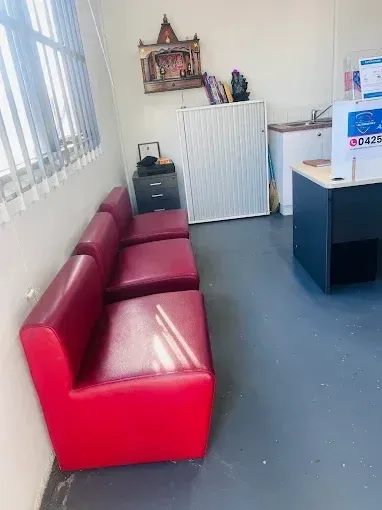 Customer waiting area with red lounge seating at P&J Automotive